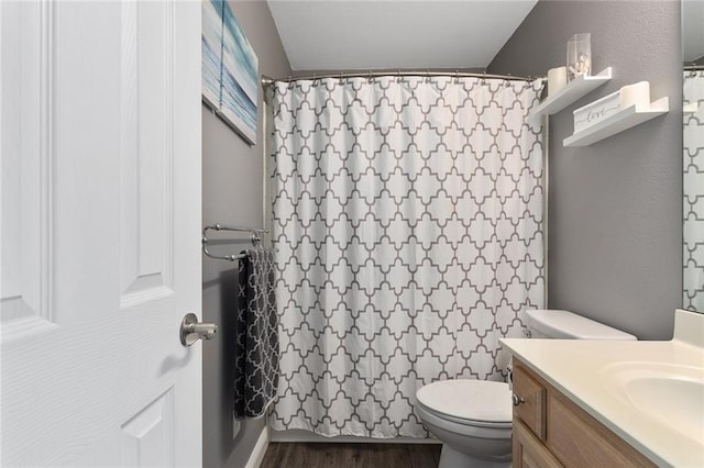 bathroom with vanity, curtained shower, toilet, and wood finished floors