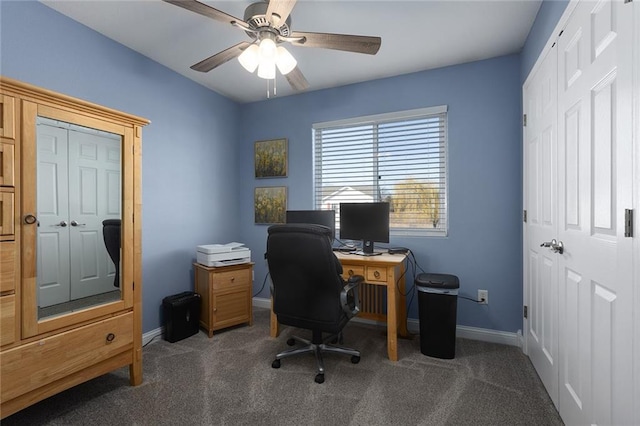 carpeted office featuring a ceiling fan and baseboards