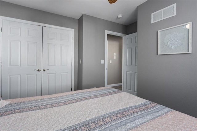 bedroom with visible vents, baseboards, and a closet