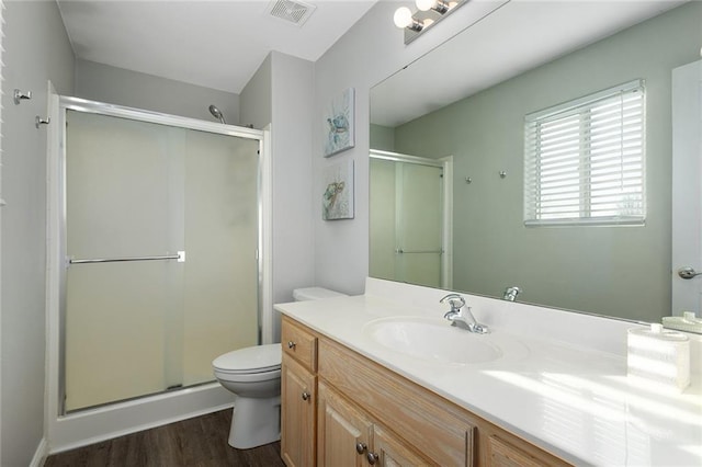 full bath with vanity, a shower stall, toilet, and visible vents