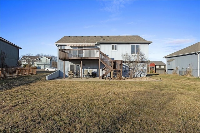 back of house with fence, a wooden deck, stairs, a lawn, and a patio