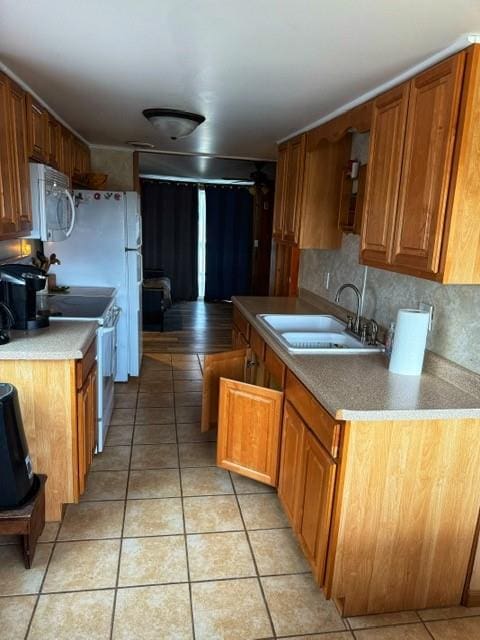 239 Mallard Ln, Big Lake, MO 64437 - kitchen featuring light tile patterned floors, a sink, brown cabinetry, stainless steel microwave, and white electric range oven