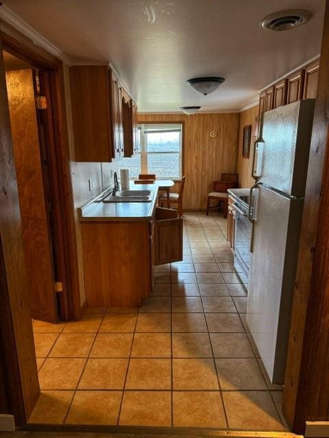 239 Mallard Ln, Big Lake, MO 64437 - kitchen featuring light tile patterned floors, visible vents, freestanding refrigerator, stainless steel range oven, and a sink