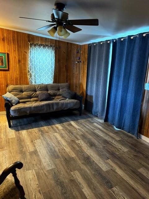 239 Mallard Ln, Big Lake, MO 64437 - unfurnished living room featuring wood walls, ceiling fan, ornamental molding, and wood finished floors