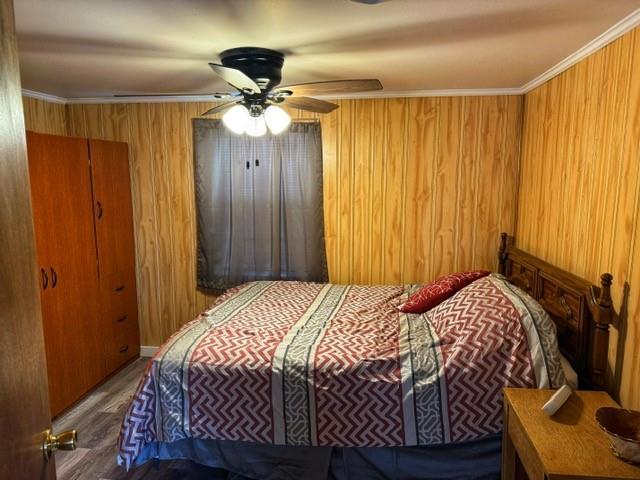 239 Mallard Ln, Big Lake, MO 64437 - bedroom with ornamental molding, ceiling fan, wood walls, and wood finished floors