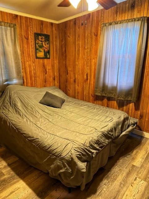 239 Mallard Ln, Big Lake, MO 64437 - bedroom with ornamental molding, a ceiling fan, wood walls, and wood finished floors