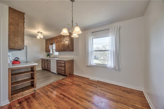 kitchen featuring light countertops, visible vents, wood finished floors, white appliances, and baseboards