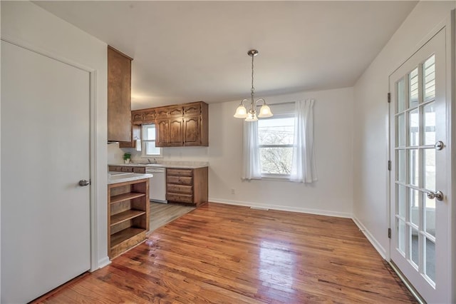 kitchen with dishwasher, light wood-style flooring, open shelves, and light countertops