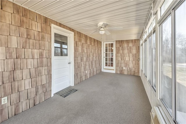 unfurnished sunroom featuring ceiling fan