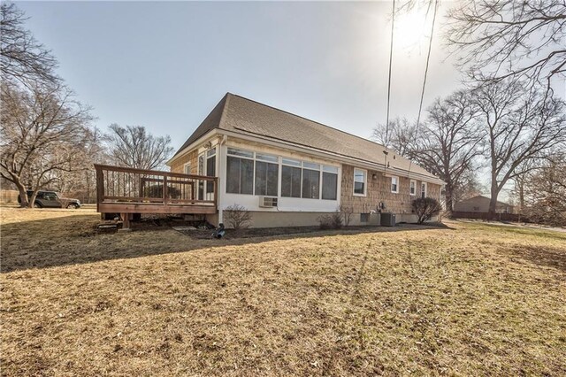 back of property with a deck and a yard