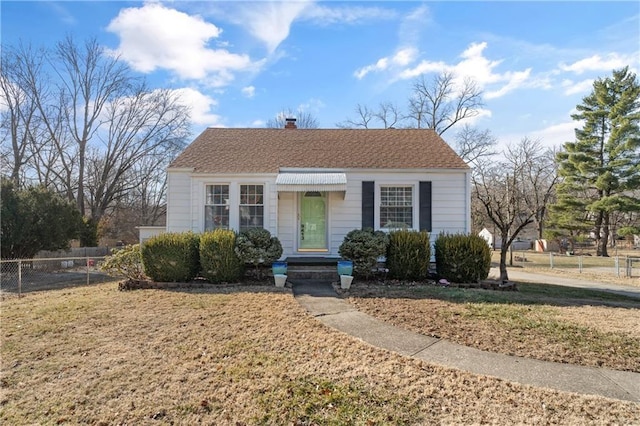 bungalow featuring a chimney, roof with shingles, a front yard, and fence