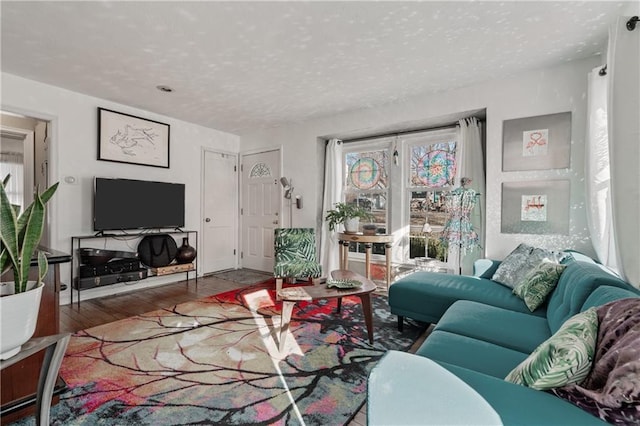 living room with a textured ceiling and wood finished floors