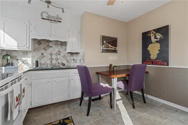 kitchen featuring white cabinetry, a ceiling fan, white electric range, and a sink