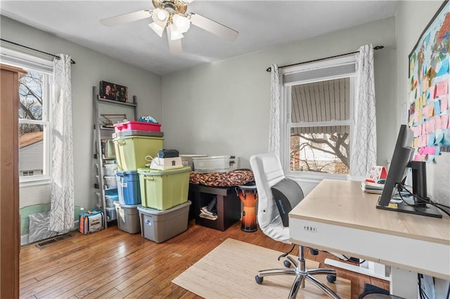 office space with visible vents, wood-type flooring, and a ceiling fan