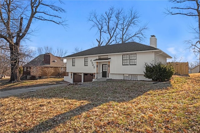 view of front facade featuring an attached garage, fence, driveway, and a chimney