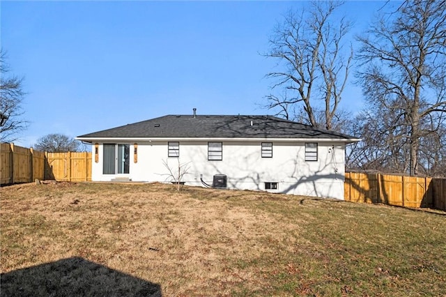 rear view of house featuring cooling unit, a lawn, and a fenced backyard