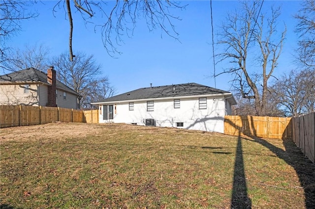 back of house featuring a yard and a fenced backyard