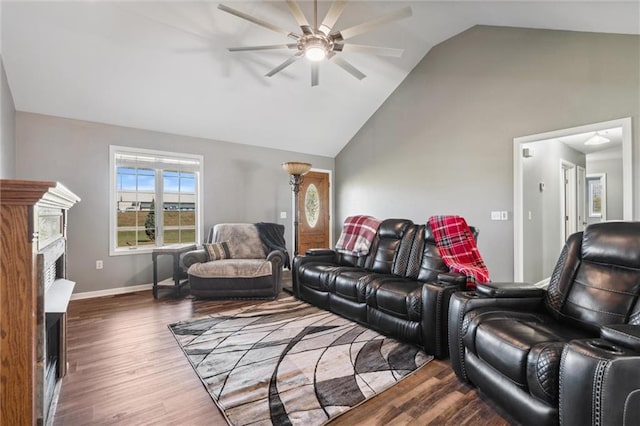 living room featuring high vaulted ceiling, a ceiling fan, wood finished floors, a fireplace, and baseboards