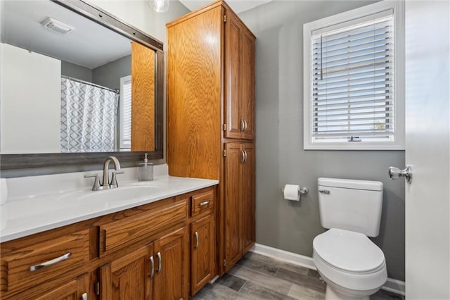 full bathroom featuring visible vents, toilet, wood finished floors, baseboards, and vanity