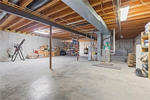 unfinished below grade area featuring heating unit and water heater