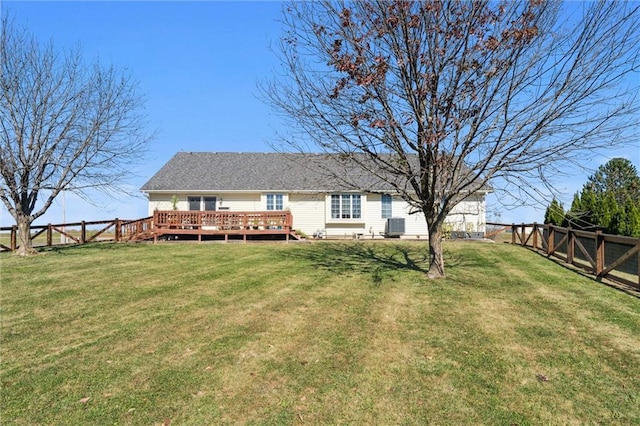 back of property with a gate, a fenced backyard, central AC, a deck, and a lawn