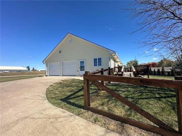 view of property exterior with a lawn, driveway, and a wooden deck