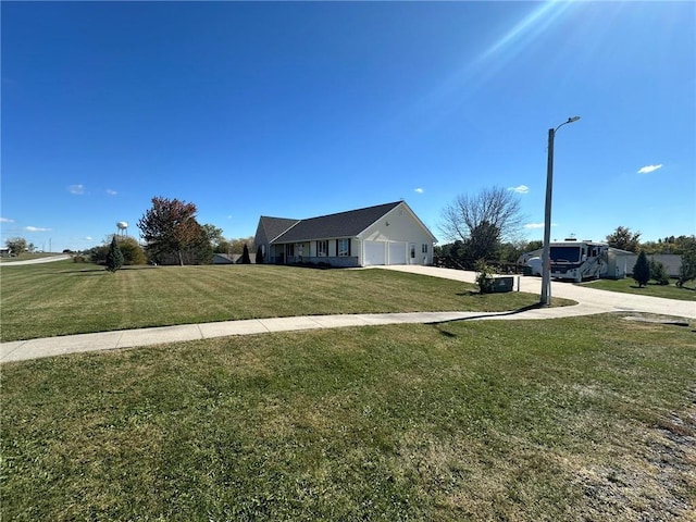 view of yard featuring driveway and a garage