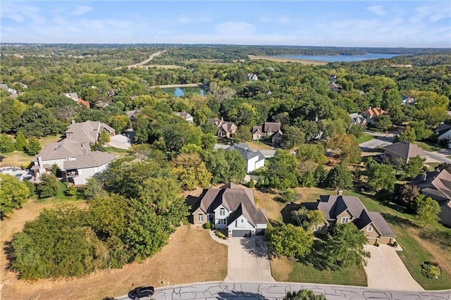 birds eye view of property featuring a water view, a forest view, and a residential view