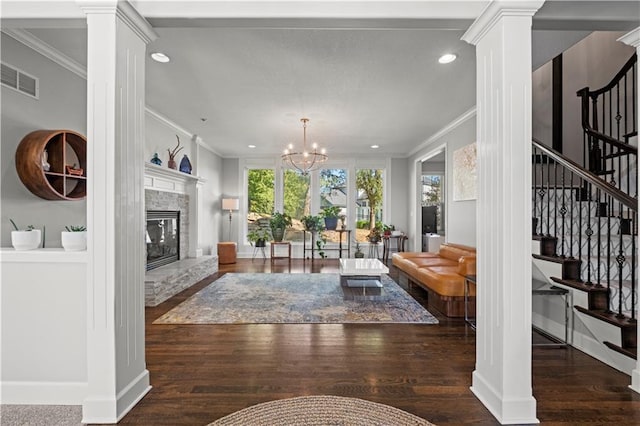 living room with crown molding, wood finished floors, and ornate columns