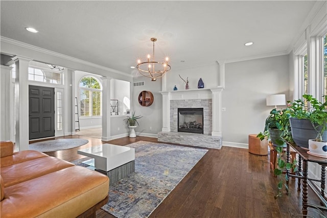 living room with crown molding, a wealth of natural light, decorative columns, and hardwood / wood-style floors