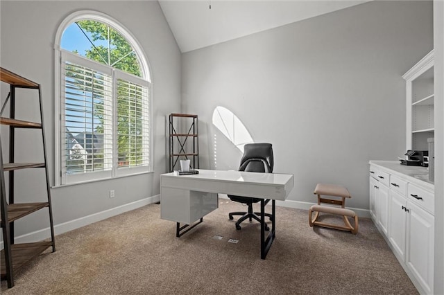 carpeted office space featuring lofted ceiling and baseboards