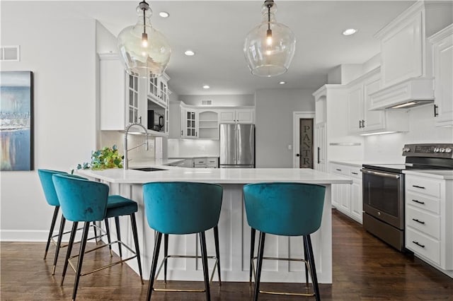 kitchen featuring custom exhaust hood, stainless steel appliances, visible vents, a sink, and a peninsula