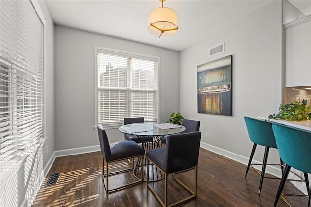 dining space featuring wood finished floors, visible vents, and baseboards