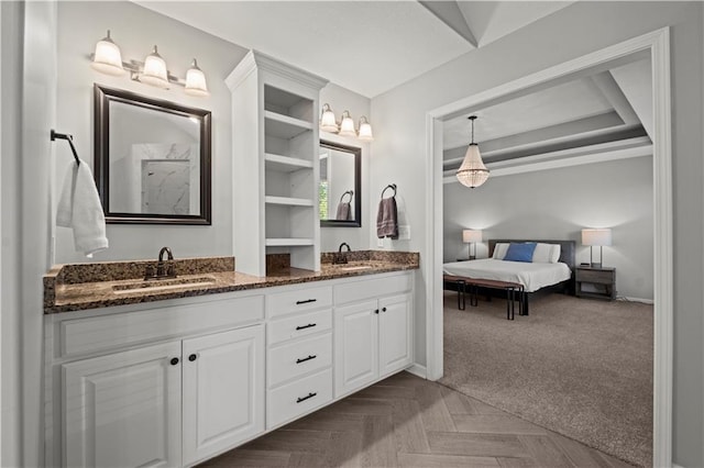 full bathroom with double vanity, a sink, and baseboards