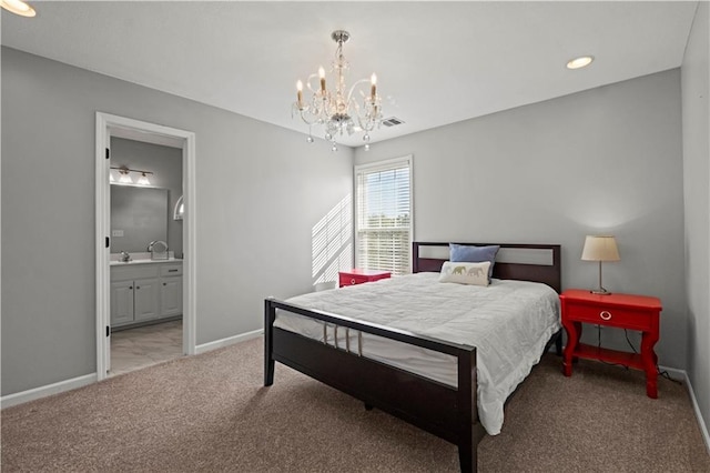 carpeted bedroom with ensuite bathroom, visible vents, and baseboards