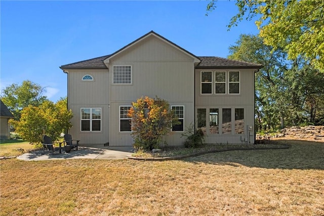 rear view of house with a yard and a patio