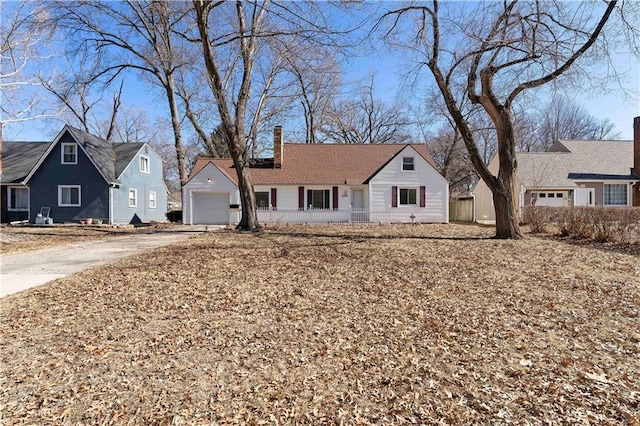 view of front of house featuring a garage, driveway, a residential view, and a chimney