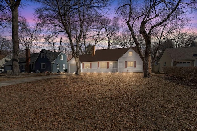 view of front facade featuring a garage and a chimney