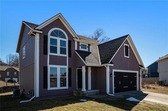 traditional-style house featuring driveway, central air condition unit, a front yard, and stucco siding