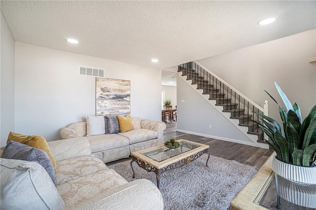 living room with stairs, wood finished floors, visible vents, and recessed lighting