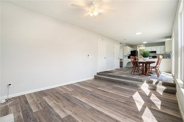 dining room featuring a ceiling fan, baseboards, and wood finished floors