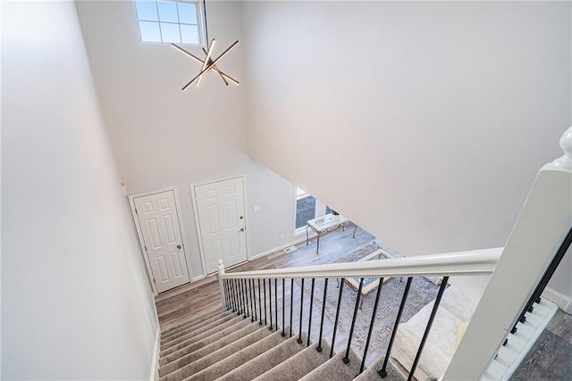 stairs with a high ceiling and wood finished floors