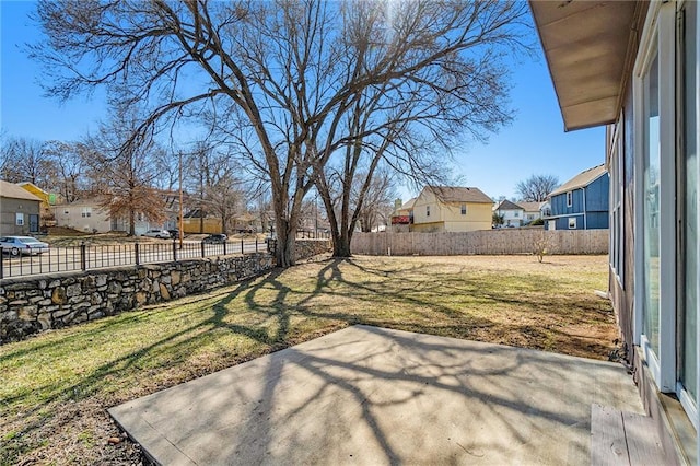 view of yard featuring a fenced backyard, a residential view, and a patio