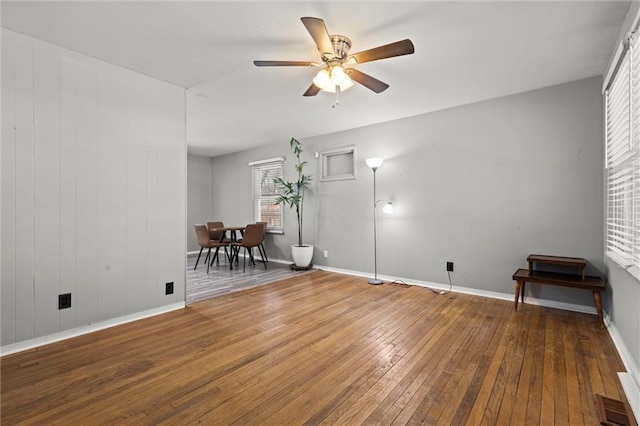 spare room with a ceiling fan, baseboards, and hardwood / wood-style floors