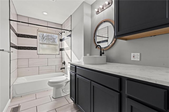 bathroom featuring toilet, vanity, visible vents, and bathing tub / shower combination