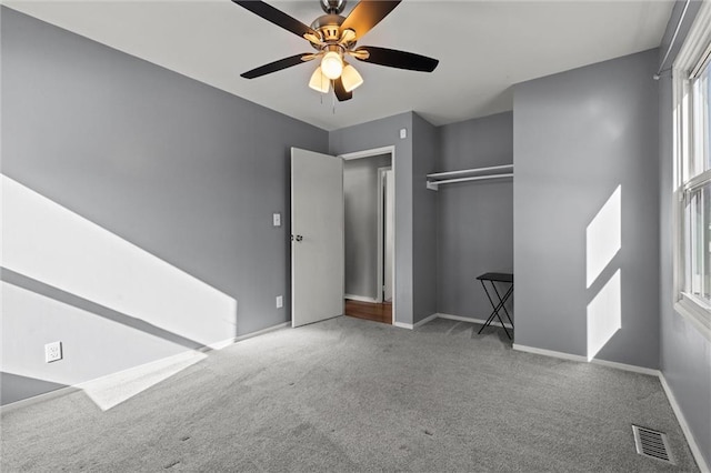 unfurnished bedroom featuring ceiling fan, visible vents, baseboards, a closet, and carpet