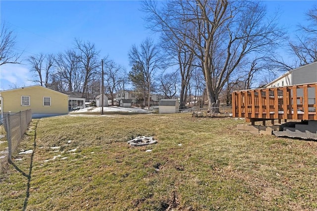 view of yard with an outdoor fire pit, fence, and a deck