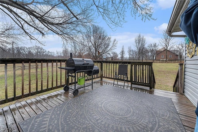 deck featuring fence, grilling area, and a lawn