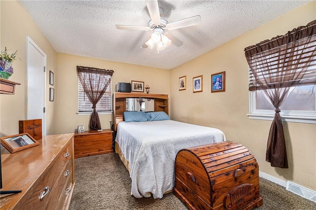 bedroom featuring a textured ceiling, carpet, visible vents, and a ceiling fan