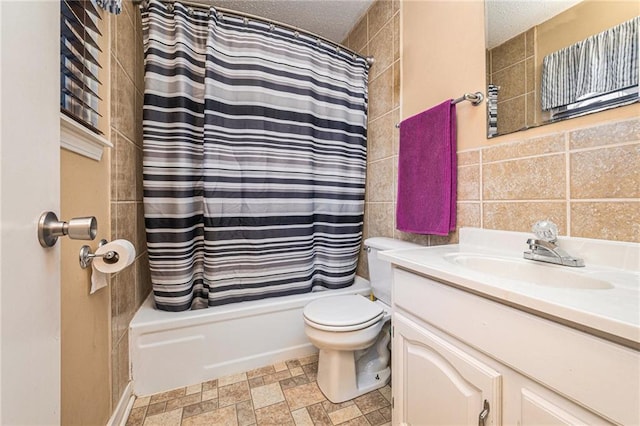 full bath with shower / bath combo, tile walls, a textured ceiling, and vanity